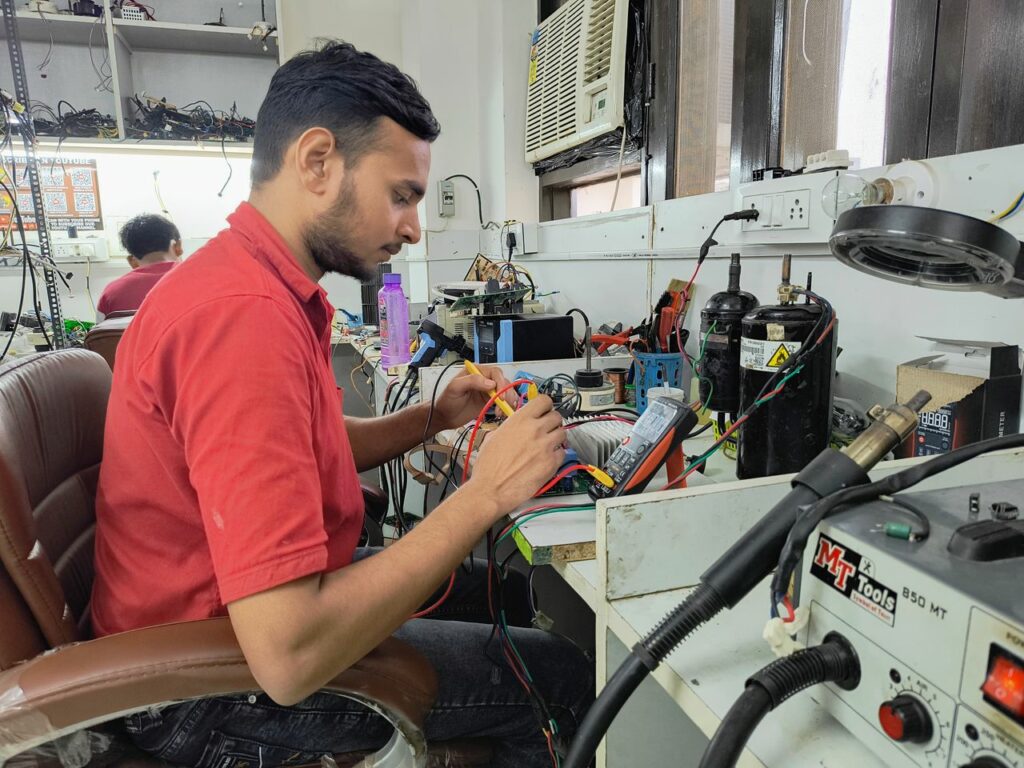 A young technician repairing electronics at a workshop. Focus on concentration and skill.